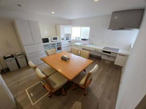 a kitchen with a wooden table and chairs in a room at Tiz円居 in Minamiawaji