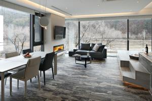 a living room with a table and a couch at Be,Bridge Pool Villa Resort in Yeongwol
