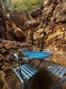a blue table and chairs next to a stone wall at Villa Gloria in Tourtour