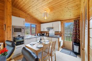 a kitchen and dining room with a table and chairs at Braeknowe Scottish Cabin Getaway in Dunkeld