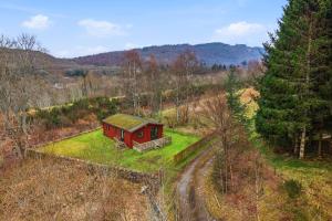 a small red house sitting on a grassy field at Braeknowe Scottish Cabin Getaway in Dunkeld