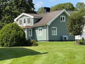 a green house with a green yard at Hagabergets Vandrarhem in Ullared
