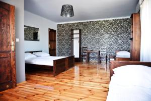 een slaapkamer met 2 bedden en een houten vloer bij Karczma We Młynie in Tuszyn