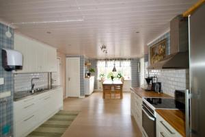 a kitchen with white cabinets and a table in it at Hagabergets Vandrarhem in Ullared