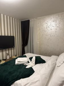 a hotel room with a bed with towels on it at Freedom RUMA 2 in Ruma