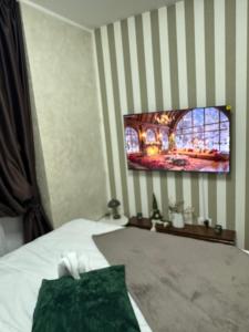 a bedroom with a bed with a tv on the wall at Freedom RUMA 2 in Ruma