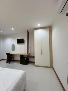 a bedroom with a bed and a desk and a cabinet at โรงแรมเมืองเลยริเวอร์วิว in Ban Tha Phae