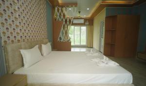 a bedroom with a large white bed with flowers on it at Siddharaj Resort in Mal bazar