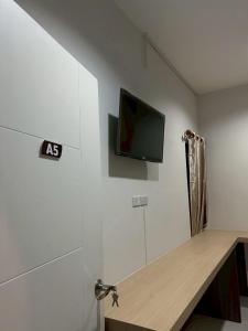 a room with a tv on a wall with a desk at โรงแรมเมืองเลยริเวอร์วิว in Ban Tha Phae