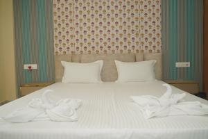 a bed with white towels on top of it at Siddharaj Resort in Mal bazar