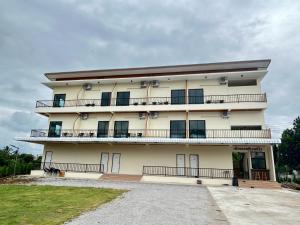 a large white building with balconies on it at โรงแรมเมืองเลยริเวอร์วิว in Ban Tha Phae