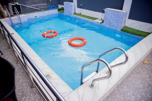 a swimming pool with two orange tubes in it at Dee Rocket Hotel & Lounge in Ibadan