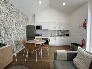 a kitchen and living room with a table and chairs at Stayin Arrifes I C in Funchal +6 photos