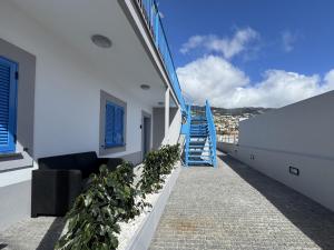 a balcony with stairs and a blue stair railing at Stayin Arrifes I C in Funchal