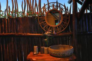 a mirror on a wooden fence with a table with a bowl at Olemayian Amboseli Cottages in Amboseli +117 photos