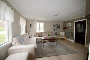 a living room with a white couch and a table at Hagabergets Vandrarhem in Ullared