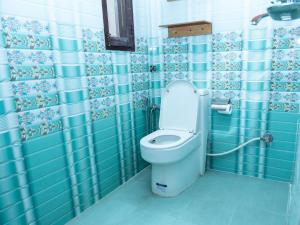 a bathroom with a toilet with blue and white tiles at Yangchen Home Hotel in Kathmandu