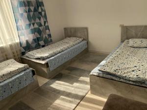 a room with two beds in a room at Жумгал гостевой дом in Chayek