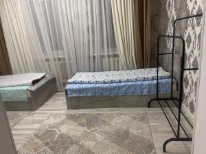 a bedroom with two beds and a window at Жумгал гостевой дом in Chayek