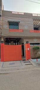 a building with an orange fence in front of it at Evergreen Escape in Lahore
