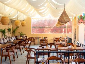 a restaurant with wooden tables and chairs and a large window at Yangchen Home Hotel in Kathmandu +34 photos