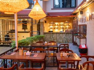 a restaurant with wooden tables and chairs and a kitchen at Yangchen Home Hotel in Kathmandu