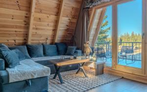 a living room with a blue couch and a table at Pine Forrest Uskoci in Žabljak