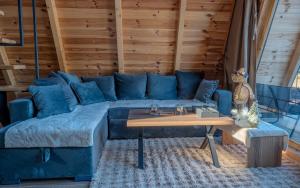 a blue couch in a room with a table at Pine Forrest Uskoci in Žabljak