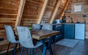 a kitchen with a wooden table and chairs in a cabin at Pine Forrest Uskoci in Žabljak +23 photos