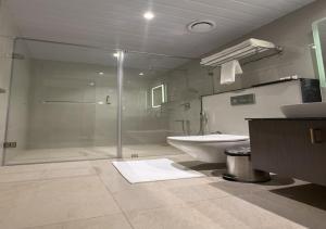 a bathroom with a shower and a toilet and a sink at Golden Suites in Bangalore +57 photos