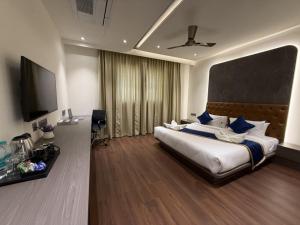 a bedroom with a large bed and a flat screen tv at Golden Suites in Bangalore