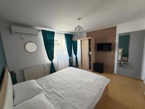 a bedroom with a large white bed and blue curtains at Hypnotic Villa Pitesti in Piteşti +72 photos