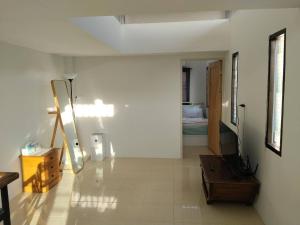 a living room with a white wall and a room with a room at Jonah by The Sea Hideaway Cabin in Ban Sam Maitri