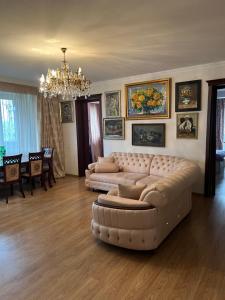 a living room with two couches and a chandelier at Big Flat in Tbilisi City +3 photos
