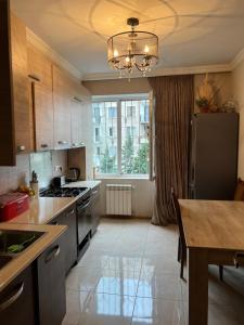 a kitchen with a table and a large window at Big Flat in Tbilisi City