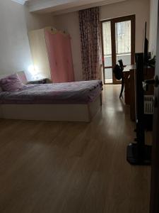 a bedroom with a bed and a desk and a television at Big Flat in Tbilisi City