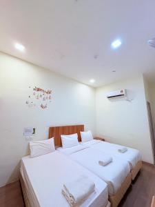 a bedroom with two beds with white sheets at SCC Velodrome KL in Kuala Lumpur