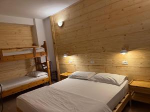 a bedroom with a bed and two bunk beds at Hotel Ristorante Sassi Rossi in Taceno