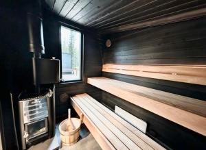 a sauna with wooden benches and a window at Spa Cabin by Hossaville in Hossa +38 photos