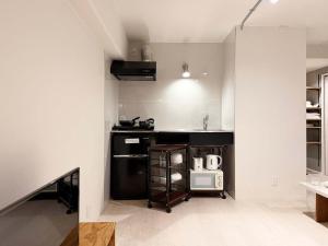 a kitchen with a black counter and a microwave at Origaminn 702 by b hotel - 5 mins PeacePark in Hiroshima +18 photos