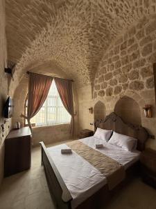 a bedroom with a large bed in a stone wall at Rocinante House in Mardin