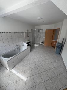 a large bathroom with a tub and a tiled floor at Ferienwohnung Emma in Marl