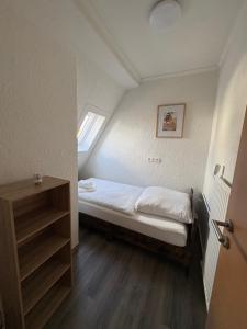 a small bed in a small room with a window at Ferienwohnung Emma in Marl