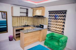 a kitchen with a counter and a green chair at Dee Rocket Hotel & Lounge in Ibadan