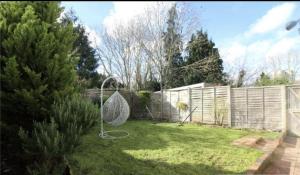 a garden with a swing in the grass at Luxury 2-Bed Apartment with Parking & Garden in Borehamwood +1 photo