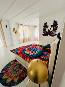 a bedroom with a colorful bed and a chair at Benthota grand villa in Nakandalagoda +16 photos