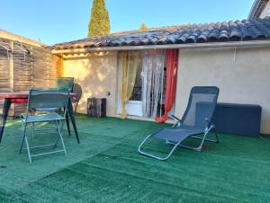 two chairs and a table on a patio at studio dans les arbres in Saint-Paulet-de-Caisson