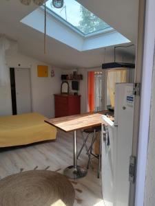 a kitchen with a table and a skylight in a room at studio dans les arbres in Saint-Paulet-de-Caisson