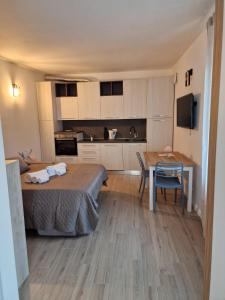 a bedroom with a bed and a table and a kitchen at BINARIO 16- new loft in Marone
