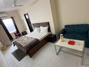 a bedroom with a bed and a couch and a table at Sundervan Resort in Alwar